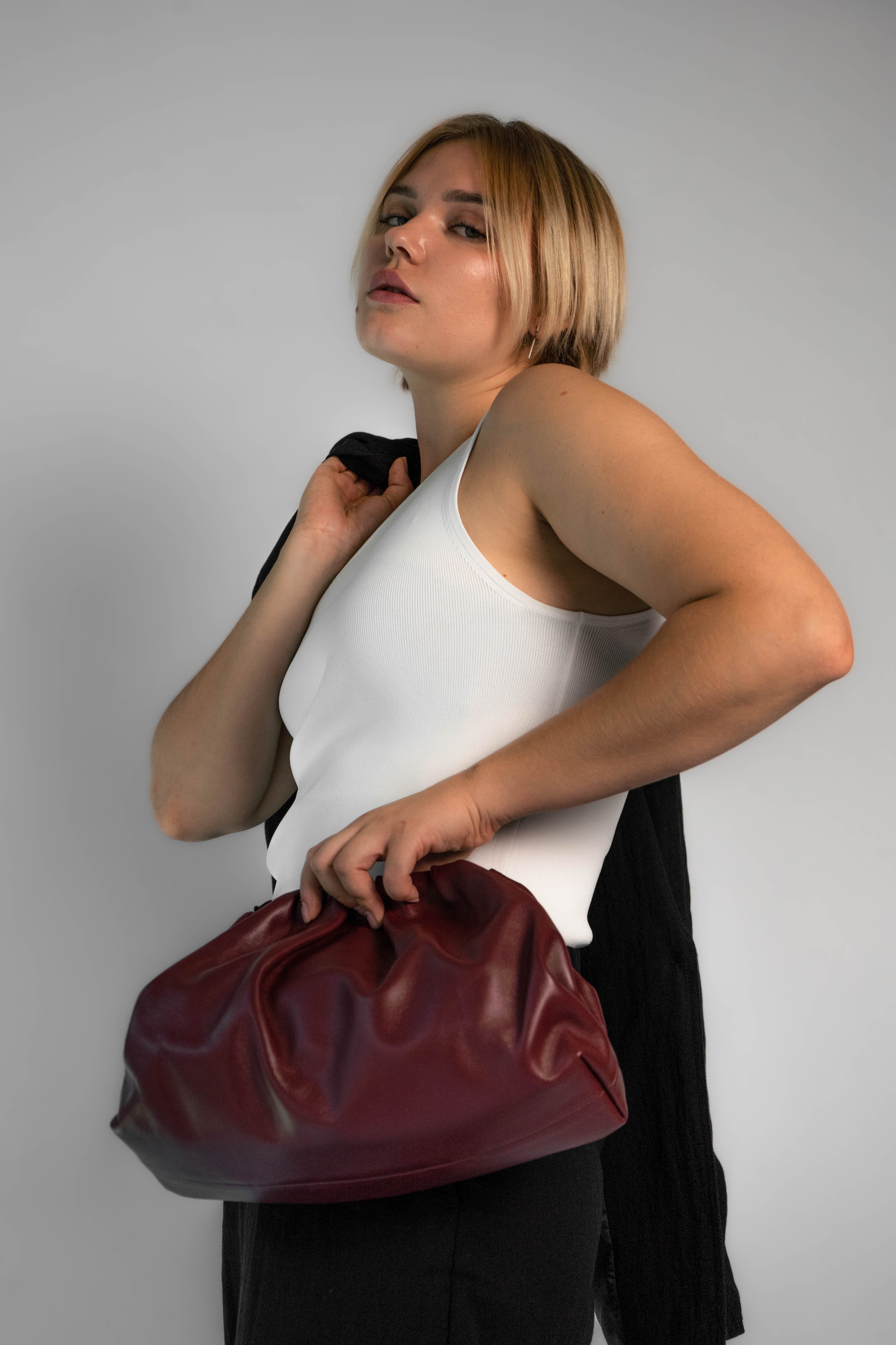 Detalle del bolso Clutch Bag Scarlet en tono burdeos con textura suave y elegante.